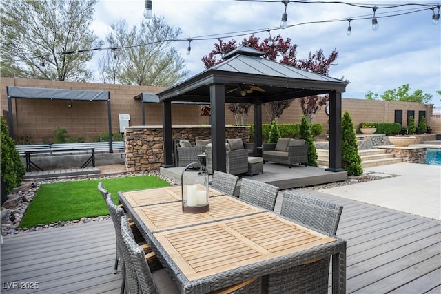 wooden deck with fence, a gazebo, an outdoor hangout area, and outdoor dining area