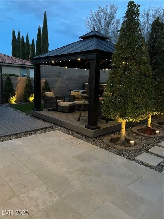 view of patio / terrace featuring a deck, fence, and a gazebo