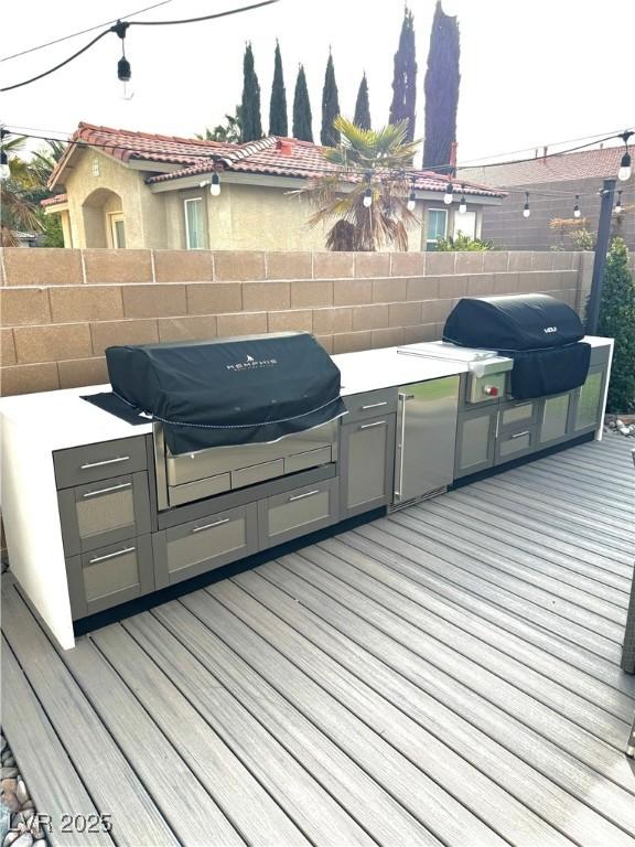 deck featuring area for grilling, grilling area, and fence