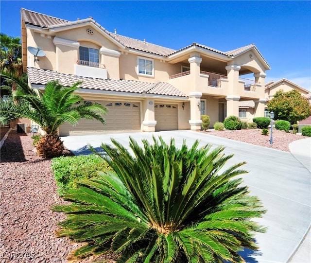 mediterranean / spanish-style house with a tile roof, concrete driveway, stucco siding, and a balcony