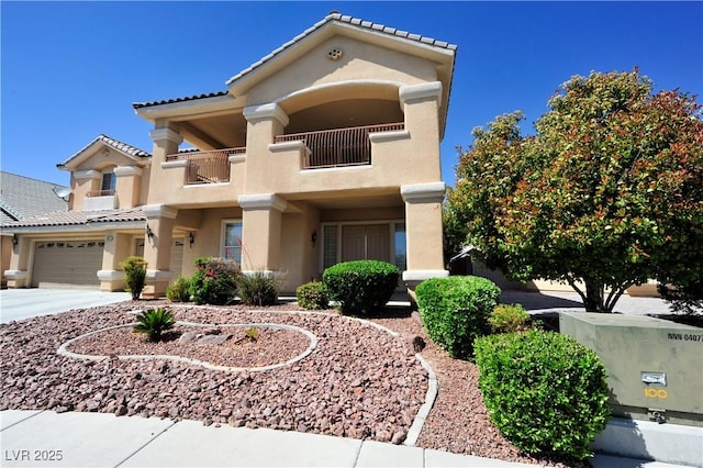 view of front of property with concrete driveway, stucco siding, a tiled roof, and a balcony