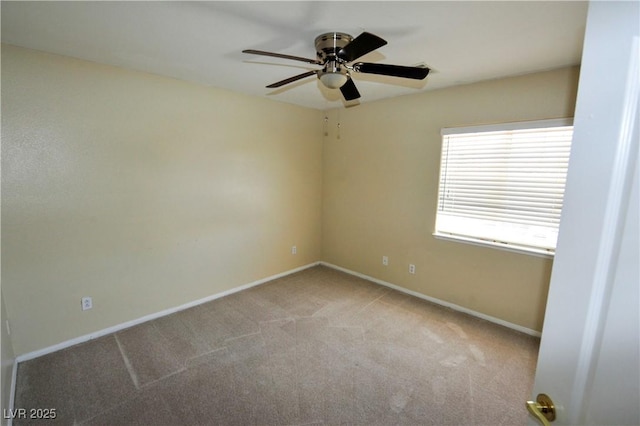 carpeted spare room featuring a ceiling fan and baseboards