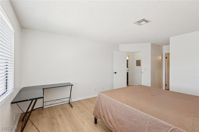 bedroom featuring a textured ceiling, wood finished floors, and visible vents