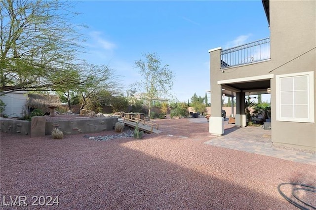 view of yard with a balcony and a patio area
