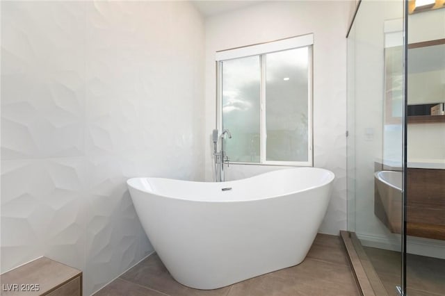 full bathroom featuring a soaking tub and tile patterned flooring