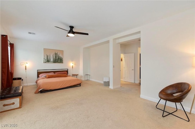 bedroom featuring light colored carpet, baseboards, and a ceiling fan