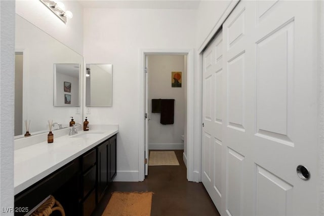 bathroom featuring vanity, toilet, and baseboards
