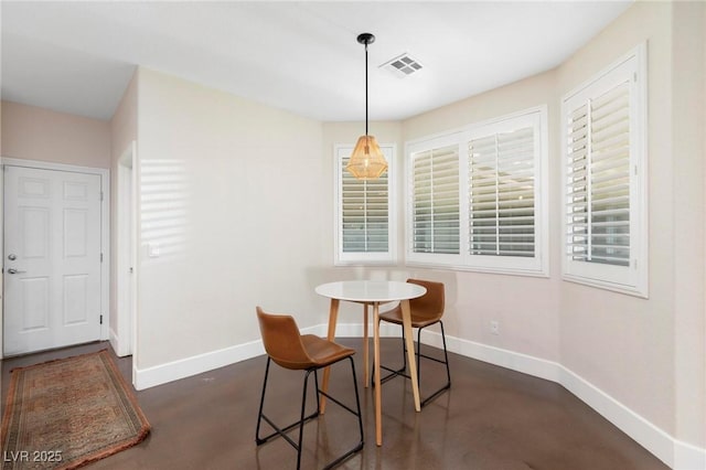 dining area with baseboards and finished concrete flooring