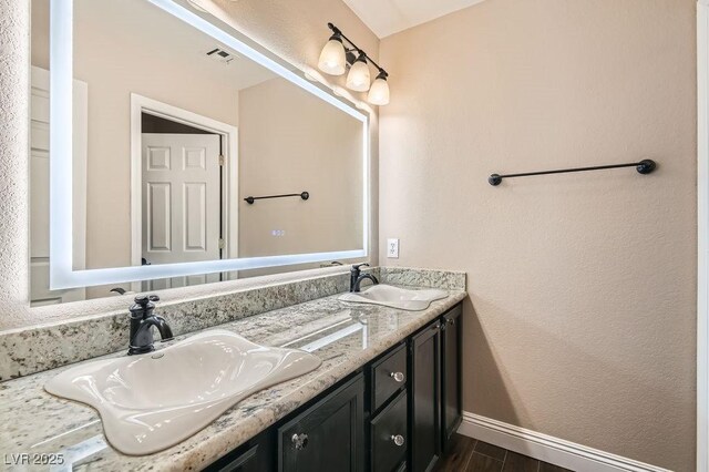 13 Cozy Glen Cir, Henderson, NV 89074 - bathroom featuring baseboards, visible vents, a sink, and wood finished floors