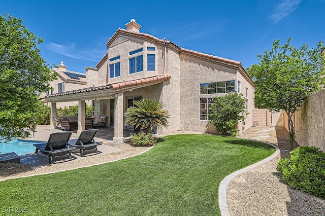 13 Cozy Glen Cir, Henderson, NV 89074 - rear view of house with a tiled roof, a chimney, a fenced backyard, a yard, and a patio