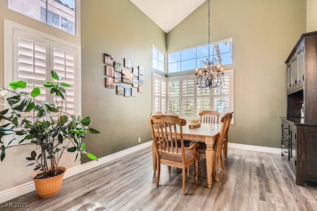 13 Cozy Glen Cir, Henderson, NV 89074 - dining area with baseboards, wood finished floors, a chandelier, and high vaulted ceiling