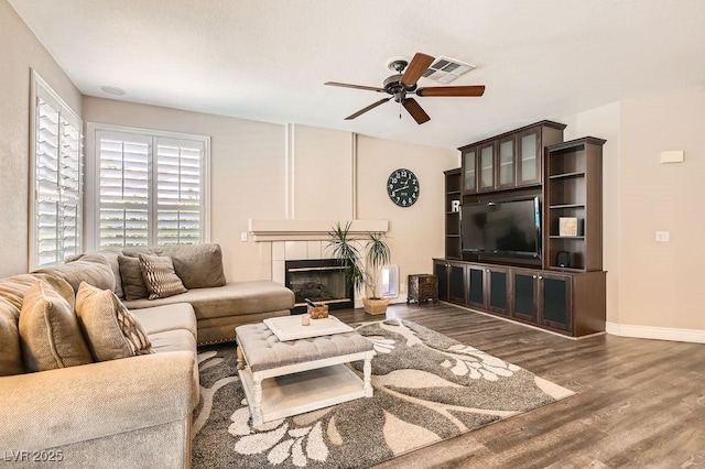 13 Cozy Glen Cir, Henderson, NV 89074 - living area featuring visible vents, wood finished floors, baseboards, ceiling fan, and a tile fireplace
