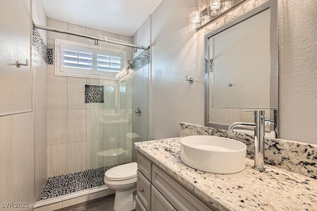 13 Cozy Glen Cir, Henderson, NV 89074 - bathroom with vanity, a textured wall, a stall shower, and toilet