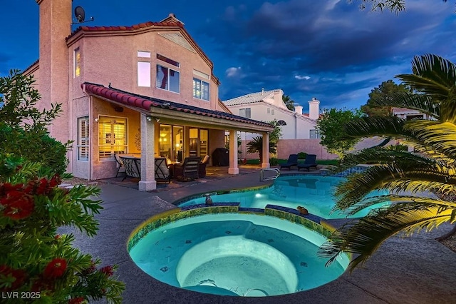 13 Cozy Glen Cir, Henderson, NV 89074 - back of house with fence, stucco siding, a patio area, a tiled roof, and a pool with connected hot tub