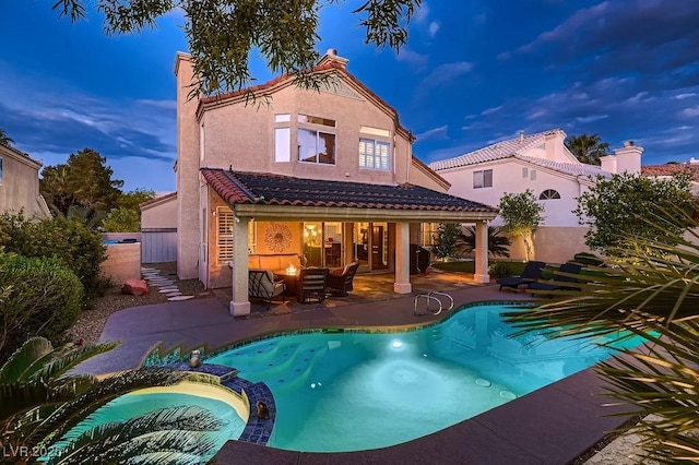 13 Cozy Glen Cir, Henderson, NV 89074 - rear view of house with a tiled roof, a pool with connected hot tub, a patio area, fence, and stucco siding