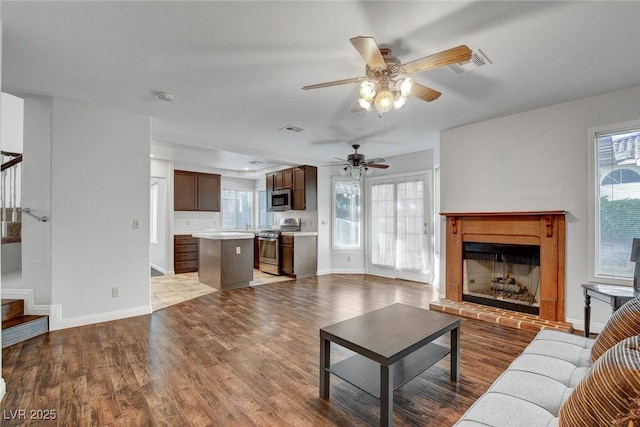 8236 Bermuda Beach Dr, Las Vegas, NV 89128 - living room featuring a fireplace, a ceiling fan, stairs, and wood finished floors