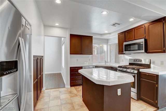 8236 Bermuda Beach Dr, Las Vegas, NV 89128 - kitchen featuring tile countertops, visible vents, a center island, stainless steel appliances, and recessed lighting