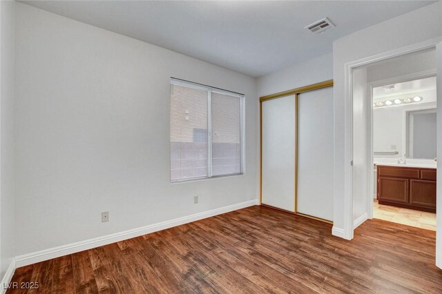 8236 Bermuda Beach Dr, Las Vegas, NV 89128 - unfurnished bedroom featuring wood finished floors and a closet
