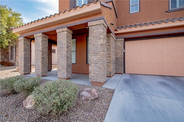 1125 Via Canale Dr, Henderson, NV 89011 - property entrance with concrete driveway, stucco siding, covered porch, and a tiled roof