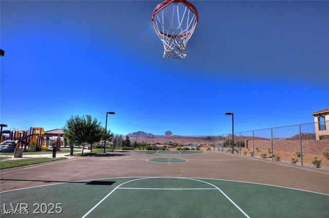 1125 Via Canale Dr, Henderson, NV 89011 - view of sport court with fence, a mountain view, and community basketball court