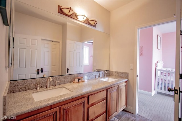 1125 Via Canale Dr, Henderson, NV 89011 - bathroom featuring double vanity, baseboards, and a sink