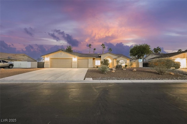 ranch-style house with a garage, fence, and driveway