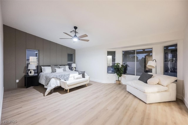 bedroom featuring baseboards, ceiling fan, light wood finished floors, and vaulted ceiling