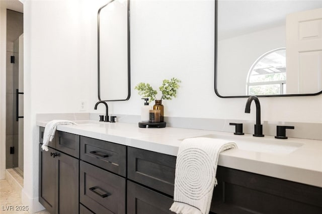 full bathroom featuring a stall shower, double vanity, and a sink