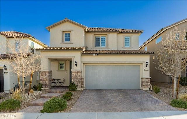 view of front facade featuring a tile roof, stucco siding, decorative driveway, stone siding, and an attached garage