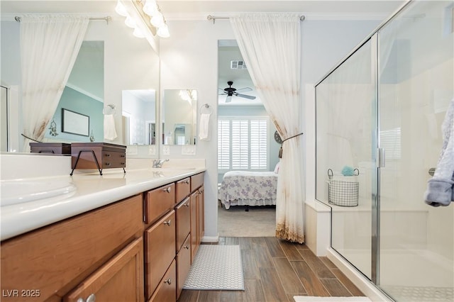 ensuite bathroom with wood finished floors, crown molding, and a ceiling fan