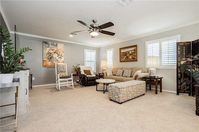 carpeted living room featuring baseboards, ornamental molding, and ceiling fan