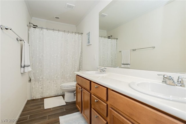 full bathroom with ornamental molding, double vanity, a sink, and wood finished floors