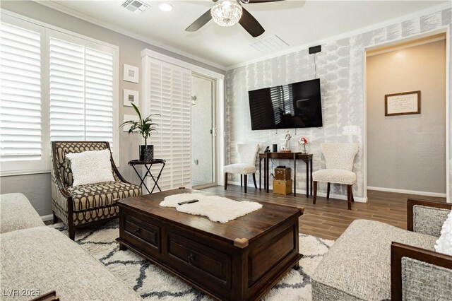 living room featuring wood finished floors, visible vents, a ceiling fan, and baseboards
