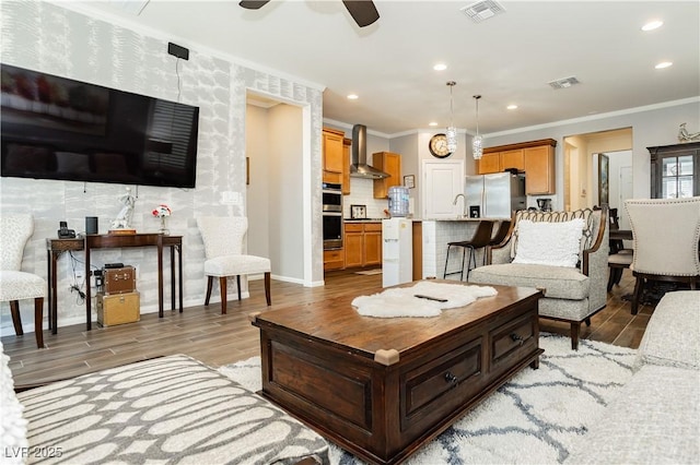 9953 Fletcher Peak Ave, Las Vegas, NV 89178 - living room with light wood finished floors, crown molding, a ceiling fan, recessed lighting, and baseboards