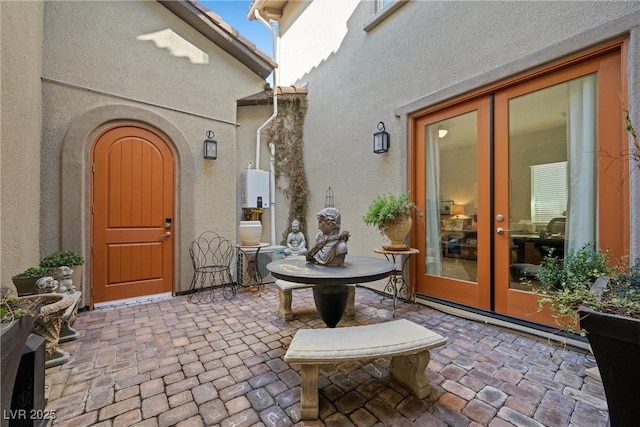 doorway to property featuring french doors, stucco siding, and a patio area