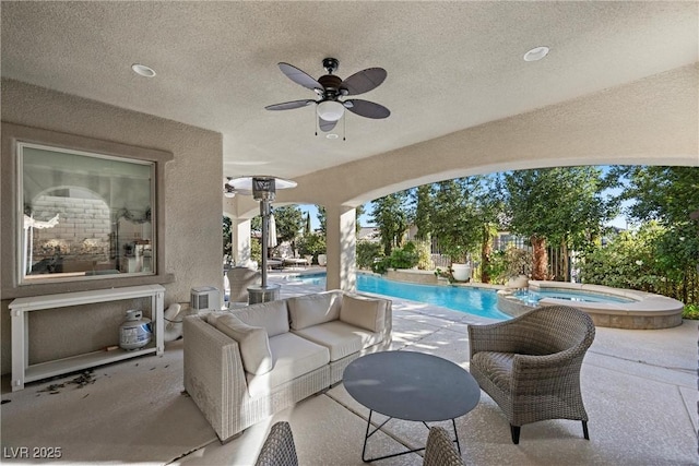 view of patio with ceiling fan and a pool with connected hot tub