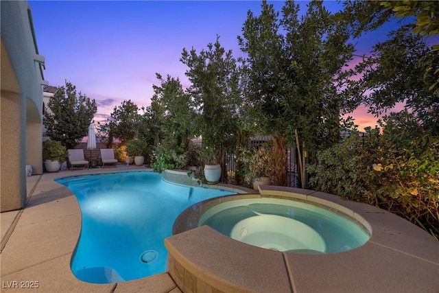 pool at dusk featuring an outdoor pool, an in ground hot tub, and fence