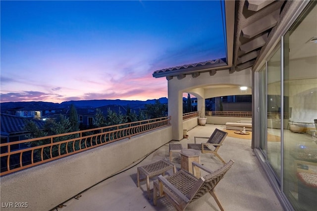 patio terrace at dusk with a mountain view and a balcony