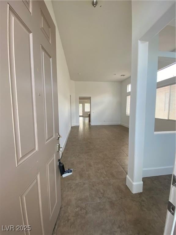 hallway with tile patterned floors and baseboards