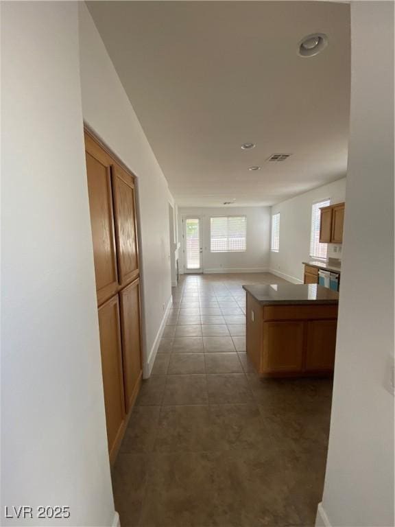 hall with visible vents, recessed lighting, tile patterned flooring, and baseboards