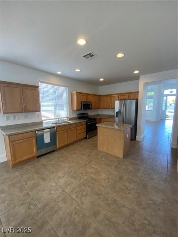 kitchen with a sink, visible vents, stainless steel appliances, a kitchen island, and recessed lighting