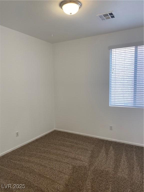 spare room featuring visible vents, baseboards, and carpet floors