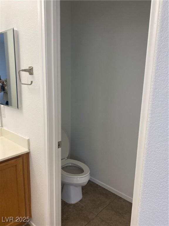 bathroom featuring baseboards, toilet, tile patterned flooring, and vanity
