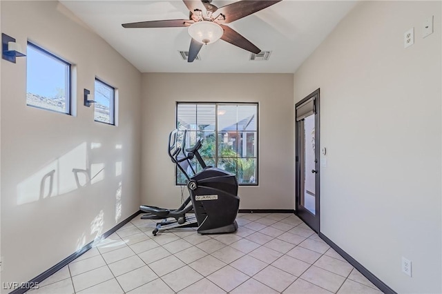 exercise area featuring baseboards, visible vents, light tile patterned floors, and a ceiling fan