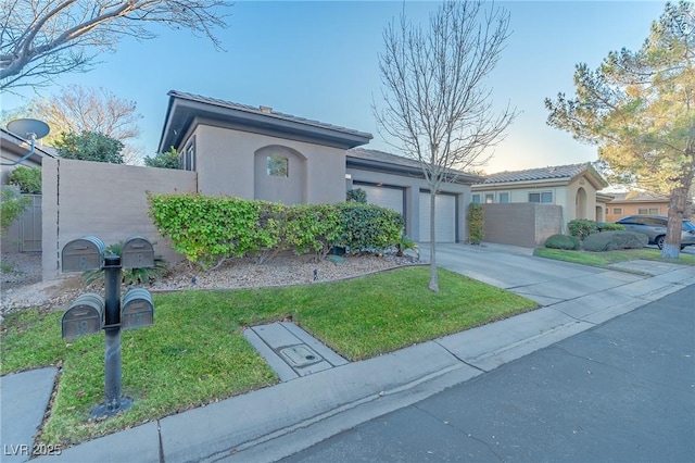 view of front of house featuring driveway, fence, a front yard, an attached garage, and stucco siding