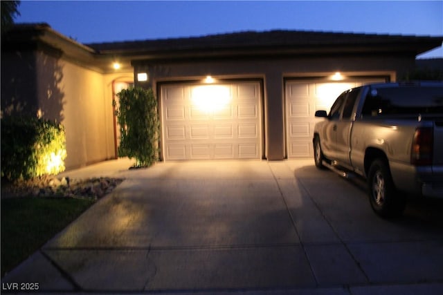 garage at twilight with concrete driveway