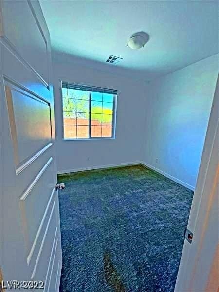 carpeted empty room featuring visible vents and baseboards