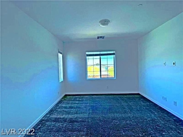 empty room featuring visible vents, baseboards, and carpet floors