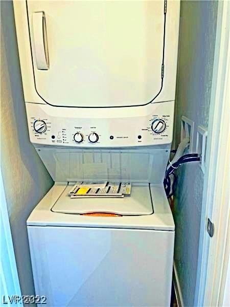 laundry room with stacked washer and clothes dryer and laundry area