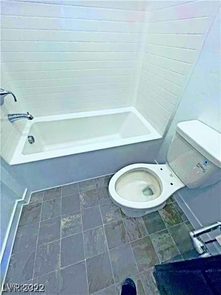bathroom featuring toilet and shower / bathtub combination
